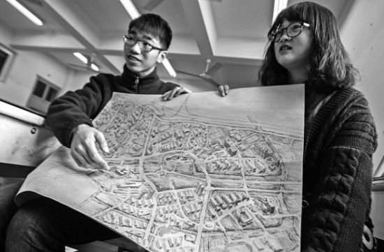 昨天上午，在永利yl23411官网，手绘图的作者郭龙(左)和何菡丹(右)在展示他们的创作手稿。 记者 姚卡/摄